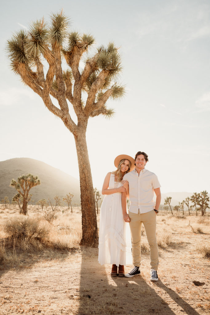 bride and groom snuggle together during engagement photos in joshua tree national park