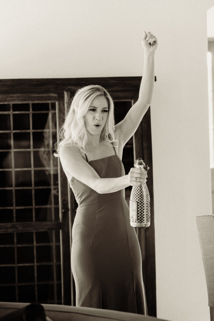 quail ranch simi valley wedding bridesmaid popping a bottle of champagne