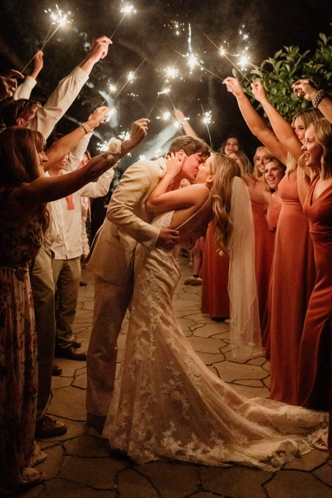 bride and groom kiss under sparkler wedding sendoff