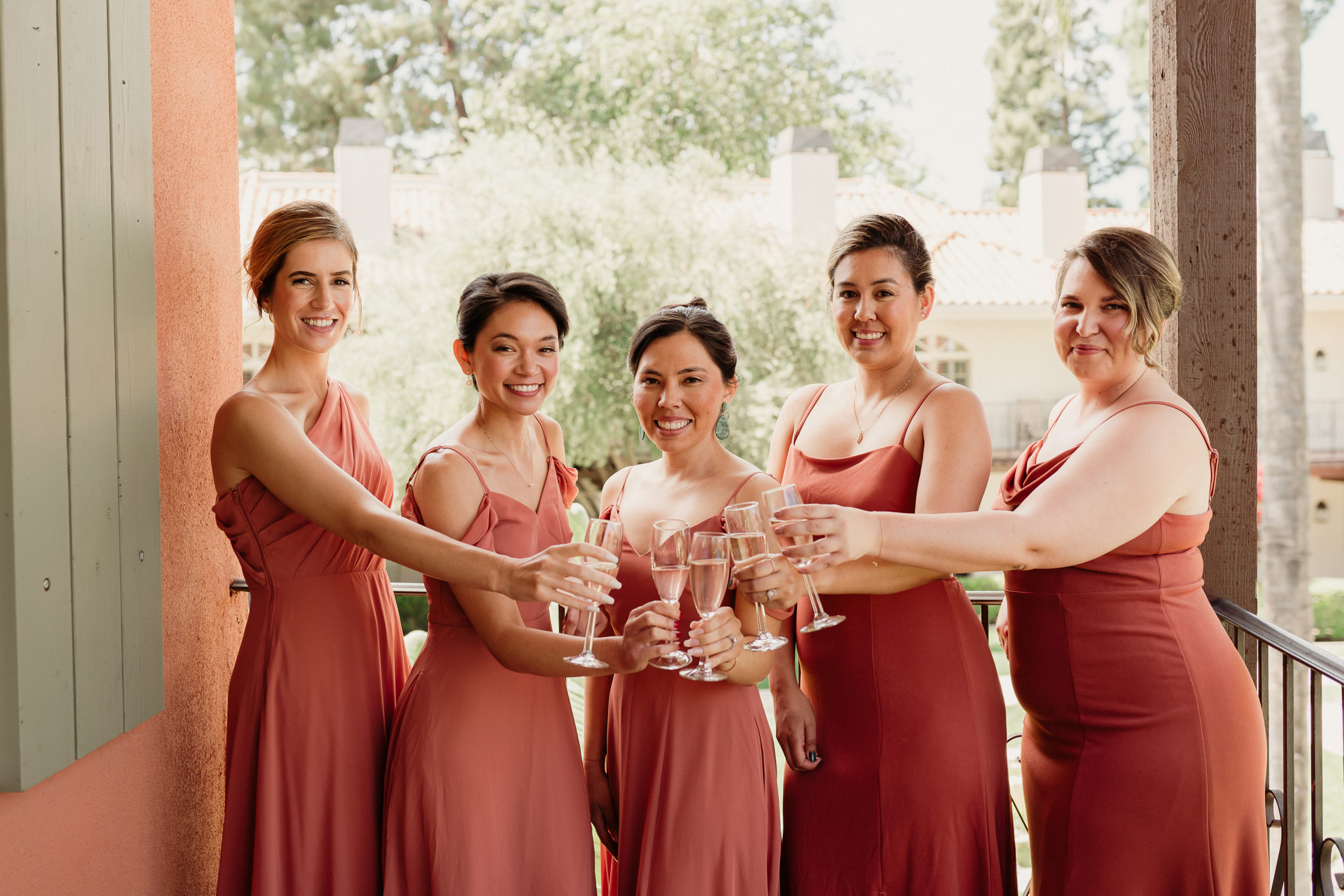 bridesmaids having a champagne toast on the balcony at The Atrium building at the Westlake Village Inn in Westlake Village, CA