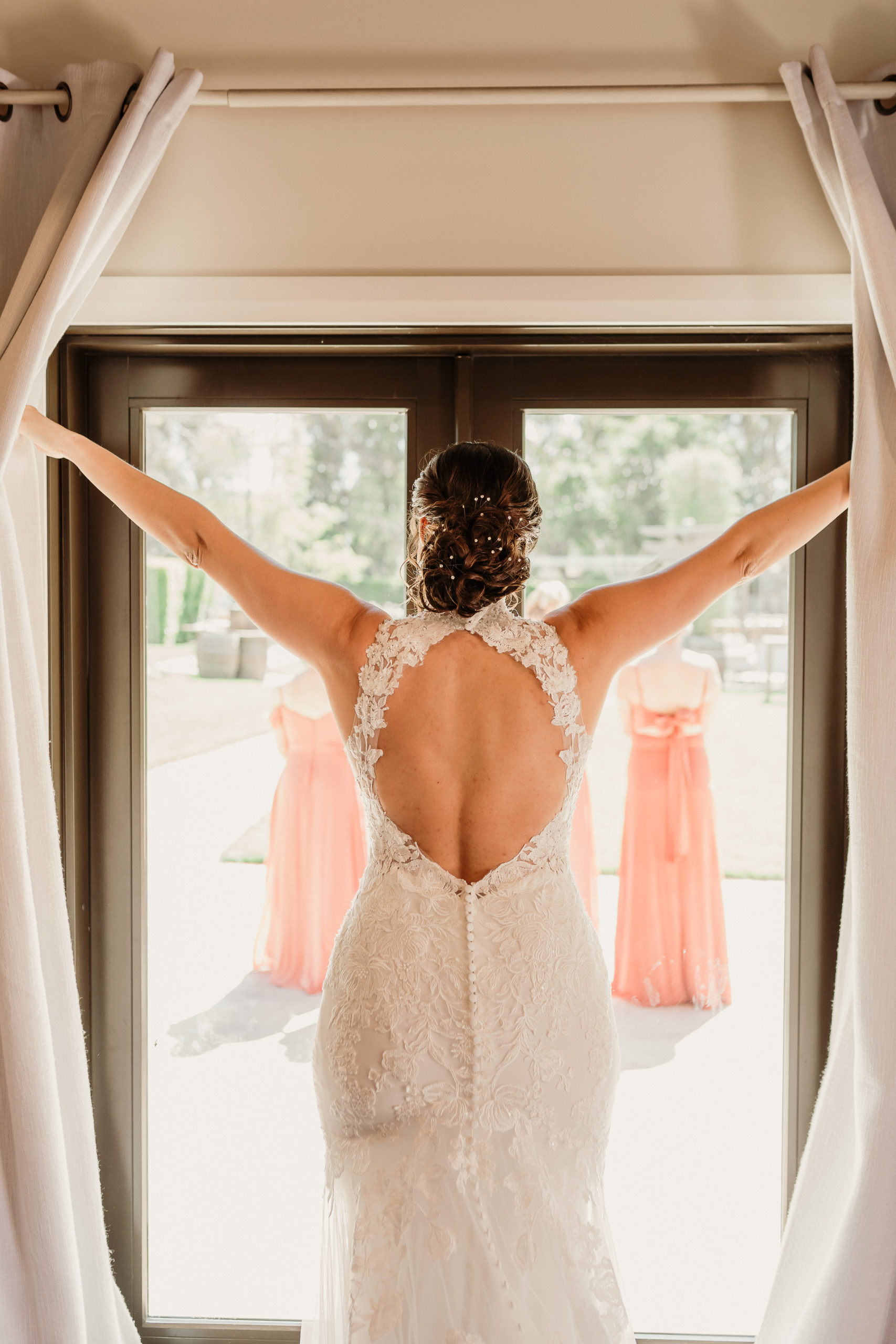 bride opens the curtain to head outside for her first look at walnut grove weddings in moorpark