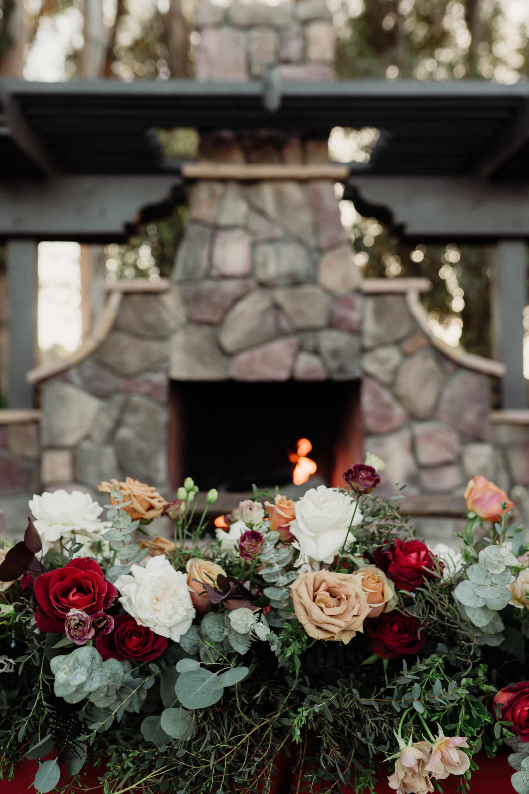 sweetheart table with rose and eucalyptus florals in front of the fireplace at walnut grove weddings
