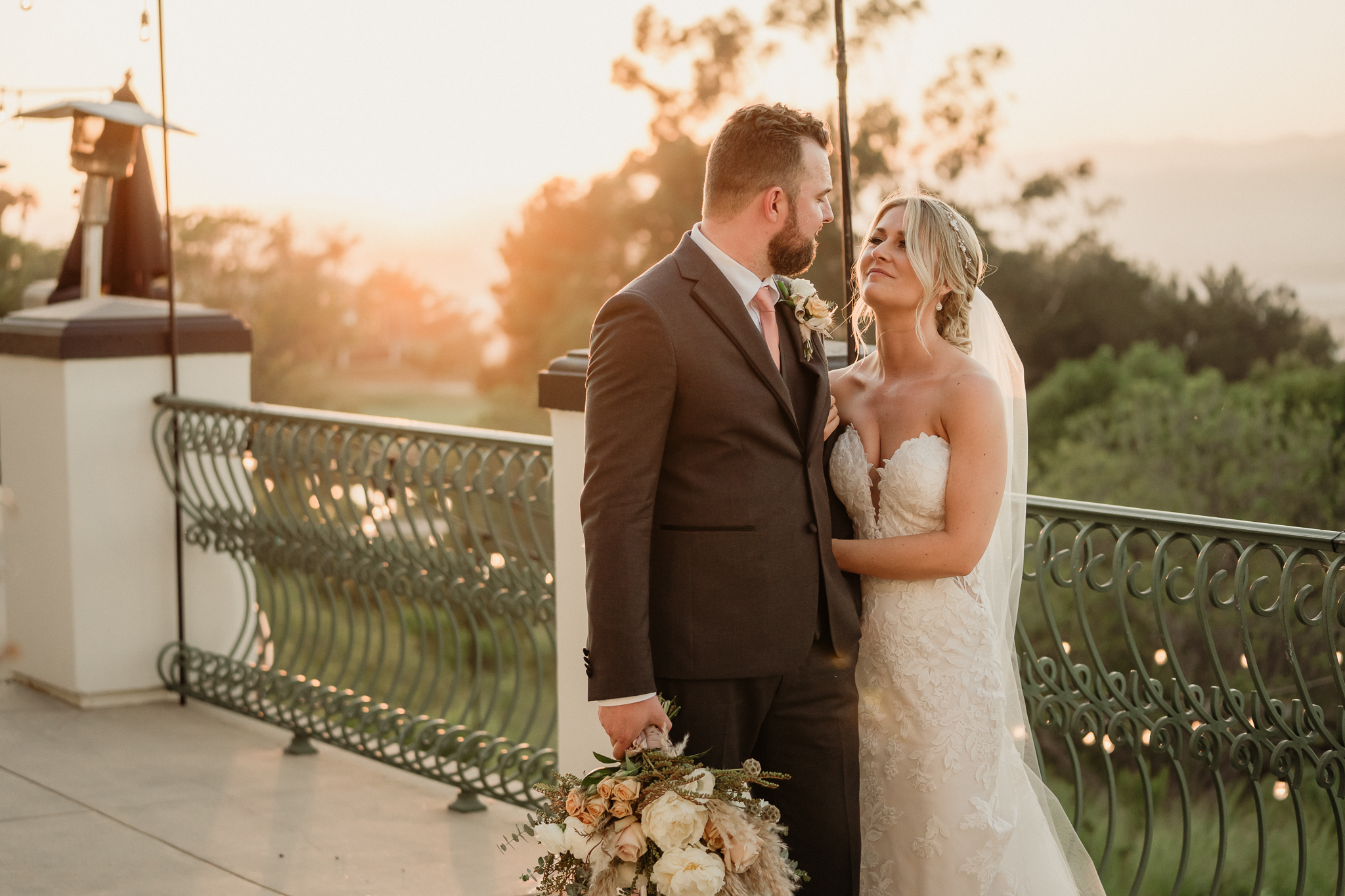 golden hour romantic bride and groom looking at each other on the balcony at spanish hills country club