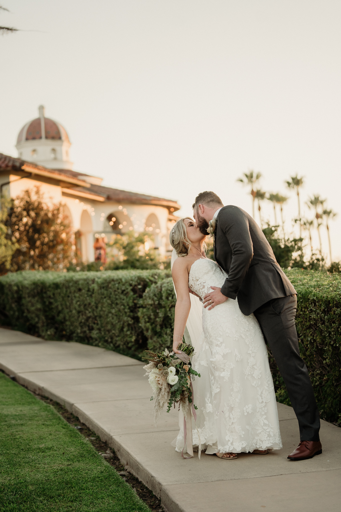 groom dips his bride and kisses her at spanish hills country club in camarillo, ca