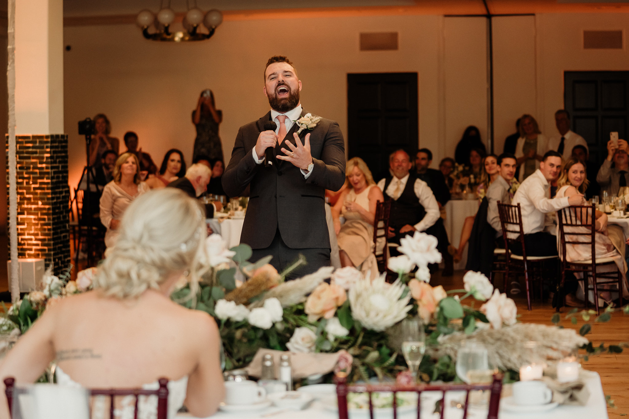 groom surprises his bride with a song during wedding reception