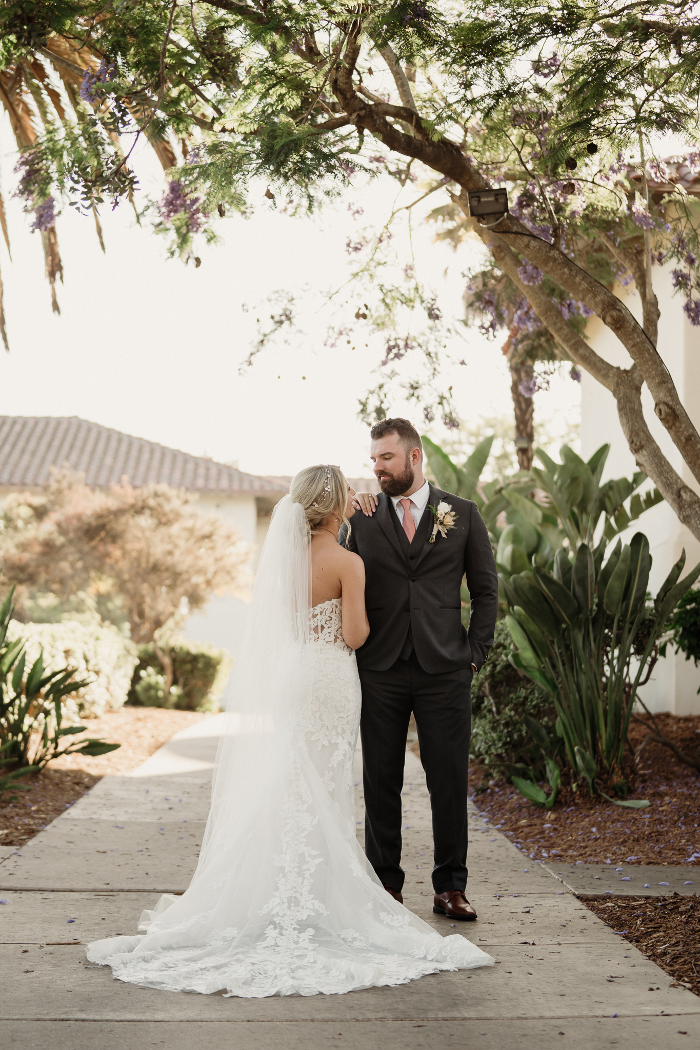romantic bride wearing a white lace wedding dress and long veil and groom portrait at spanish hills country club