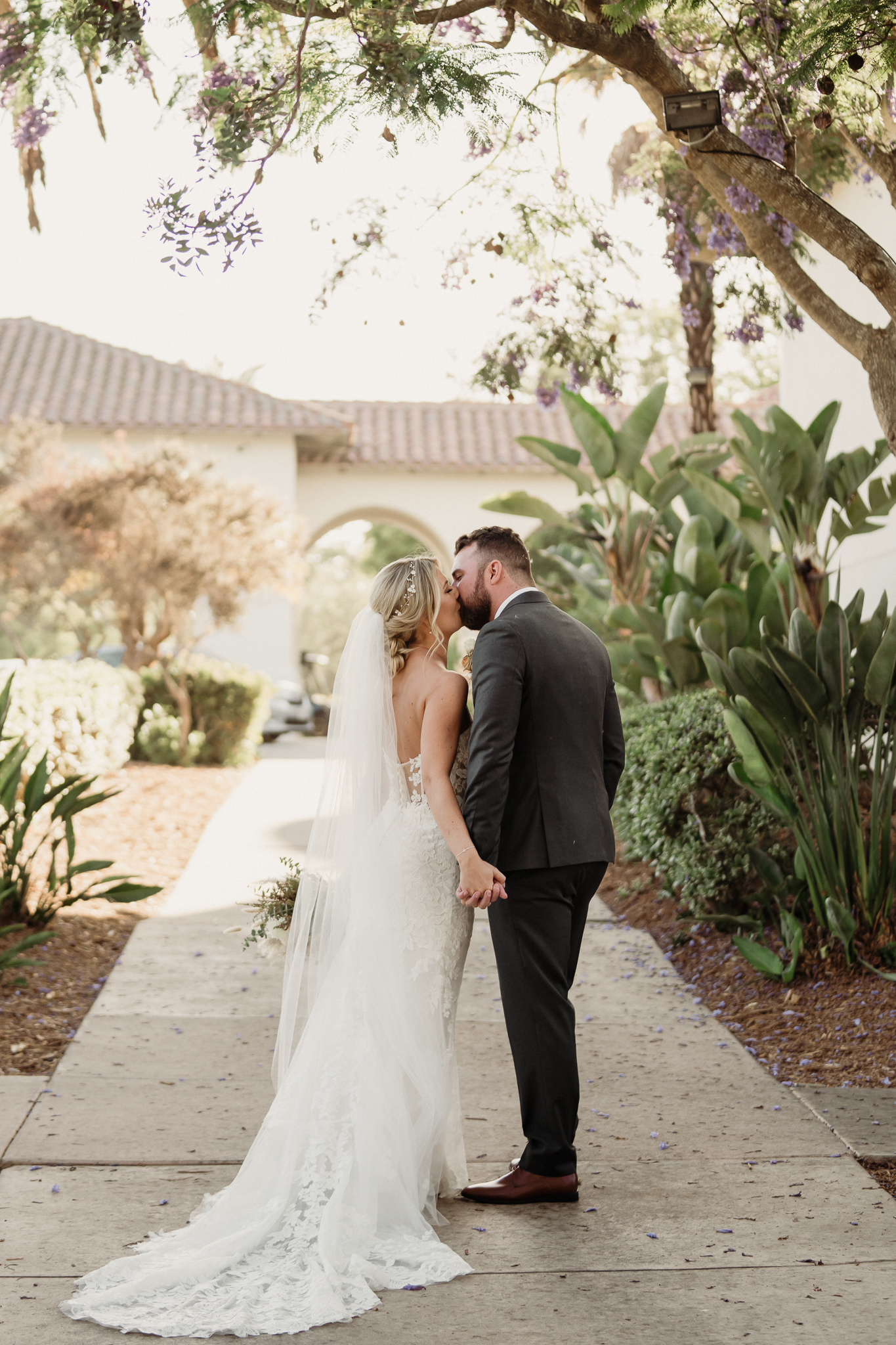 bride and groom walk down the sidewalk holding hands at spanish hills country club