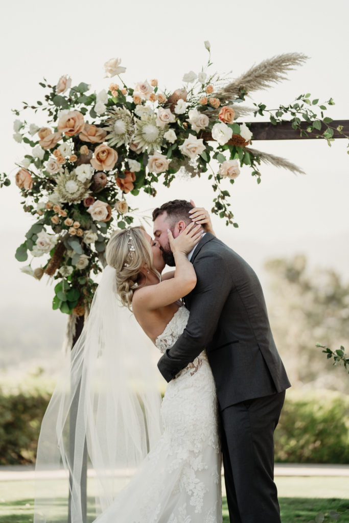 bride and groom first kiss at wedding photos at spanish hills country club in camarillo, ca | spanish hills country club wedding photographer