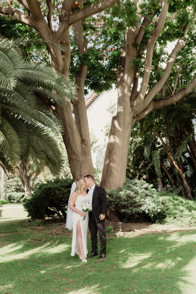 bride and groom kiss under the marriage tree at the santa barbara courthouse after their elopement