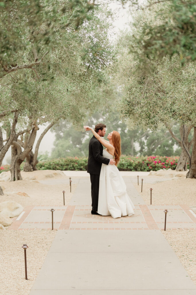 bride and groom stand in editorial pose in the olive tree grove at the montecito club in montecito ca santa barbara