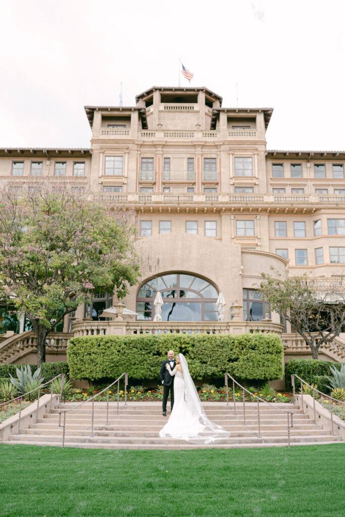 bride and groom standing on the steps of the Langham Hotel in Pasadena captured by Los Angeles wedding photographer Magnolia West Photography