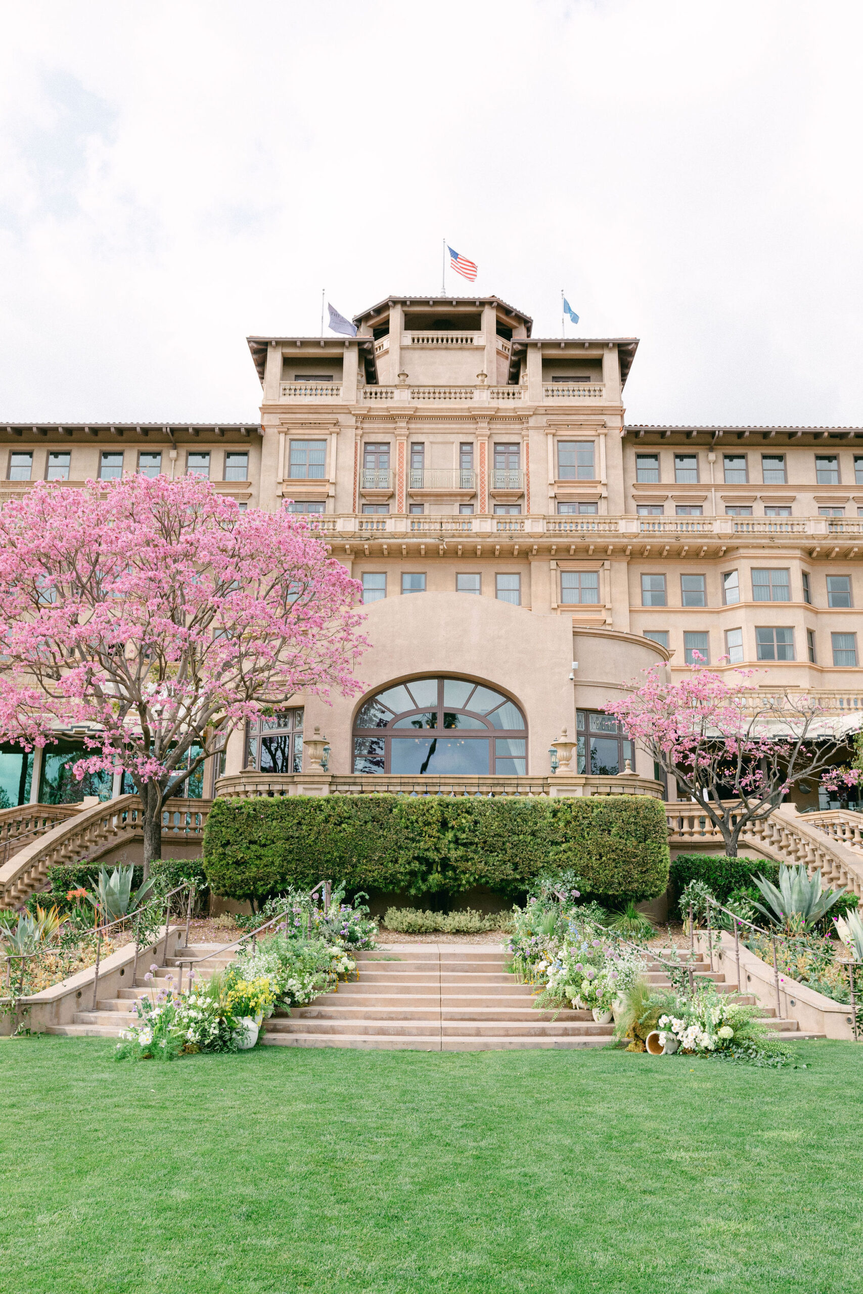 The steps behind The Langham Huntington, Pasadena adorned with flowers and grasses for a wedding. Captured by Magnolia West Photography.