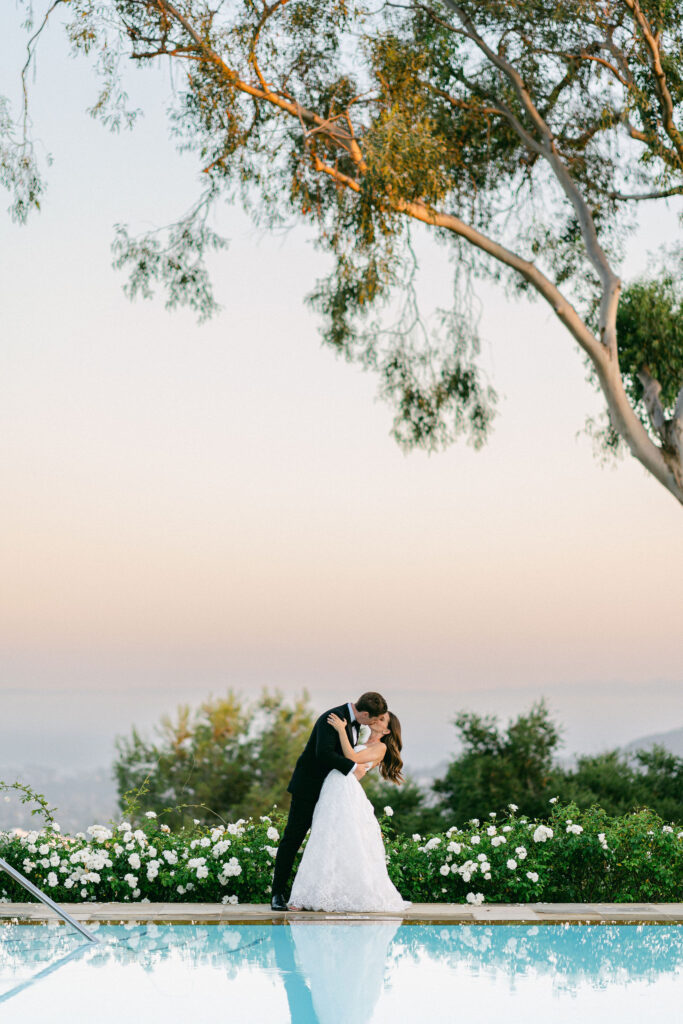 bride and groom kissing at the end of the pool at their Belmond El Encanto wedding during golden hour in Santa Barbara captured by Santa Barbara wedding photographer Magnolia West Photography